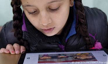 Una niña mira la pantalla de una tablet durante una actividad educativa