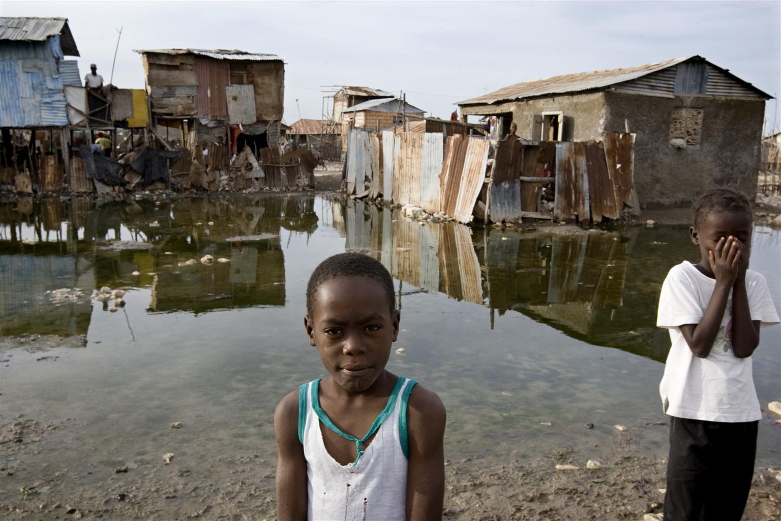 Dos niños posan frente a la cámara durante las inundaciones provocadas en Haití por el huracán Tomás en 2010.