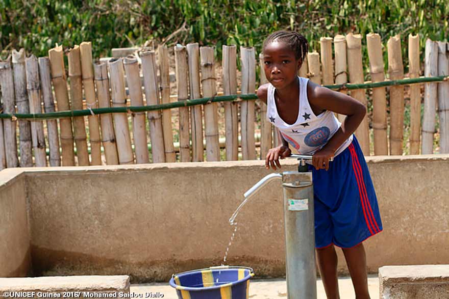 Las vidas de Gobou Kolie y su hija, Madeleine (en la foto), han cambiado bruscamente desde que UNICEF hizo un nuevo pozo en su aldea en Guinea