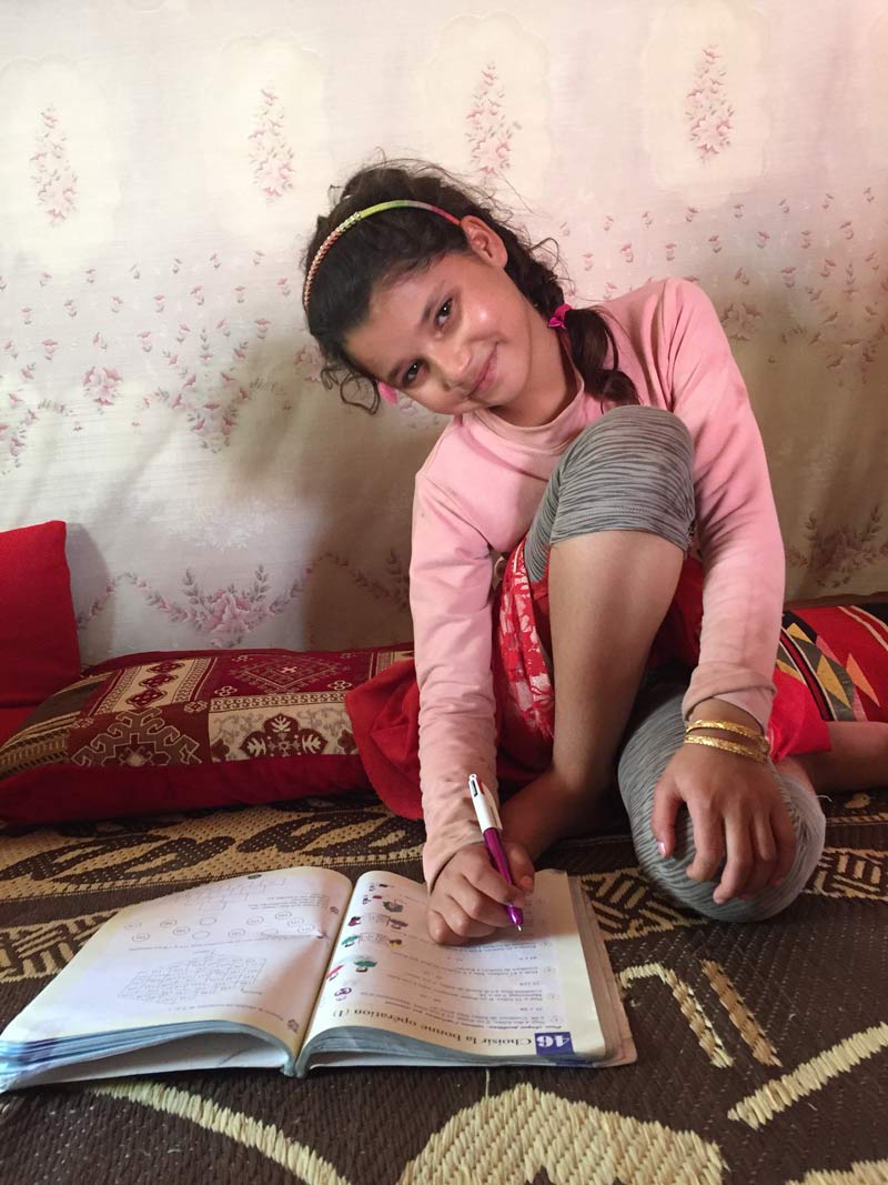 Ghossoun niña libanesa con libro del asentamiento de Al Aghidiya