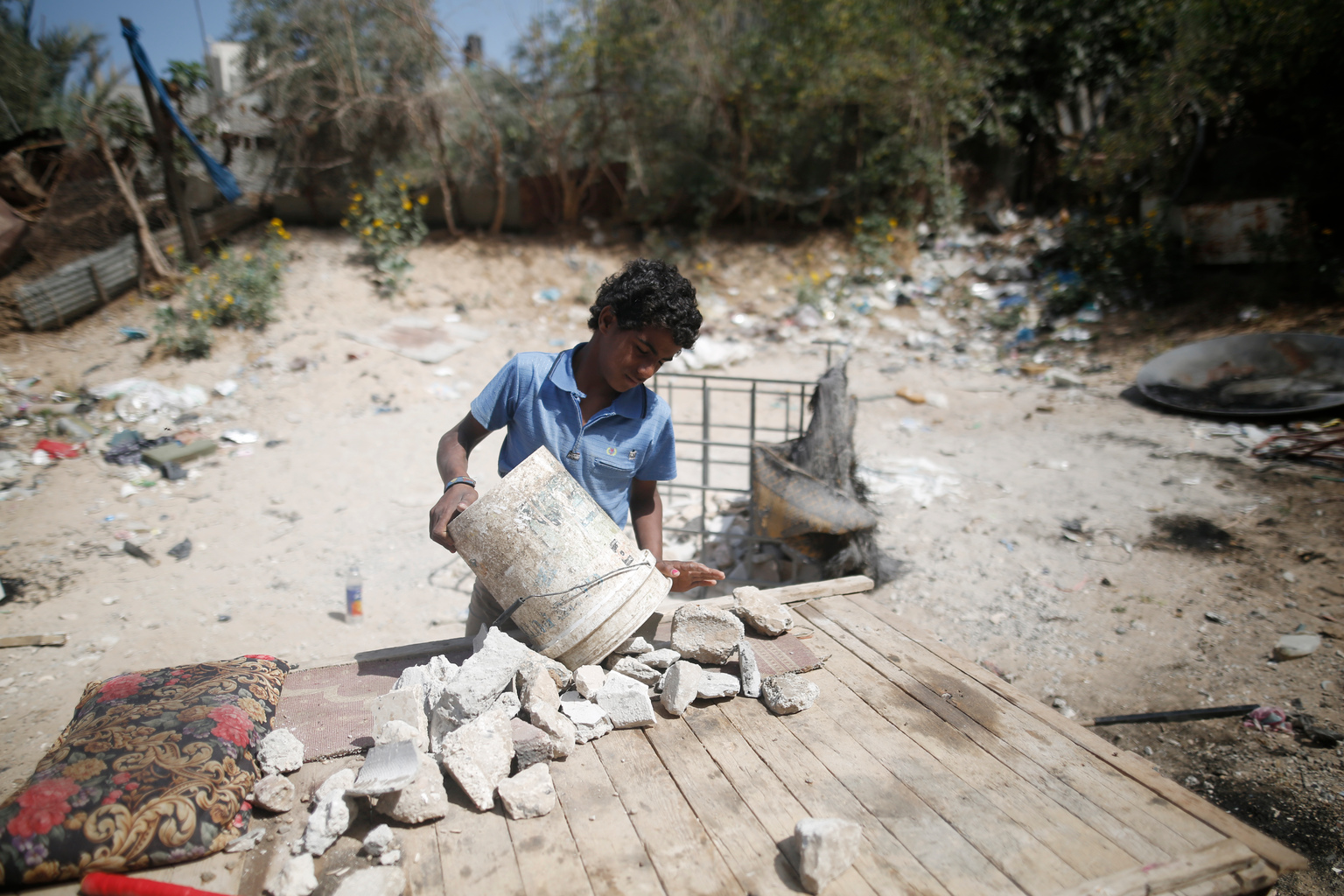 Ahmad, de trece años, que no asiste a la escuela, recoge escombros cerca de la ciudad de Gaza, Palestina