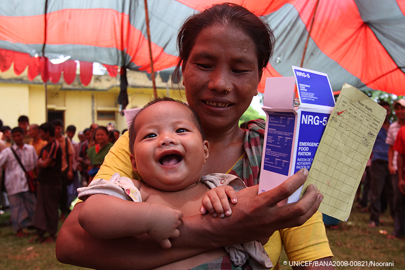 Una mujer con su hijo y unas galletas altamentes nutritivas en Bangladesh