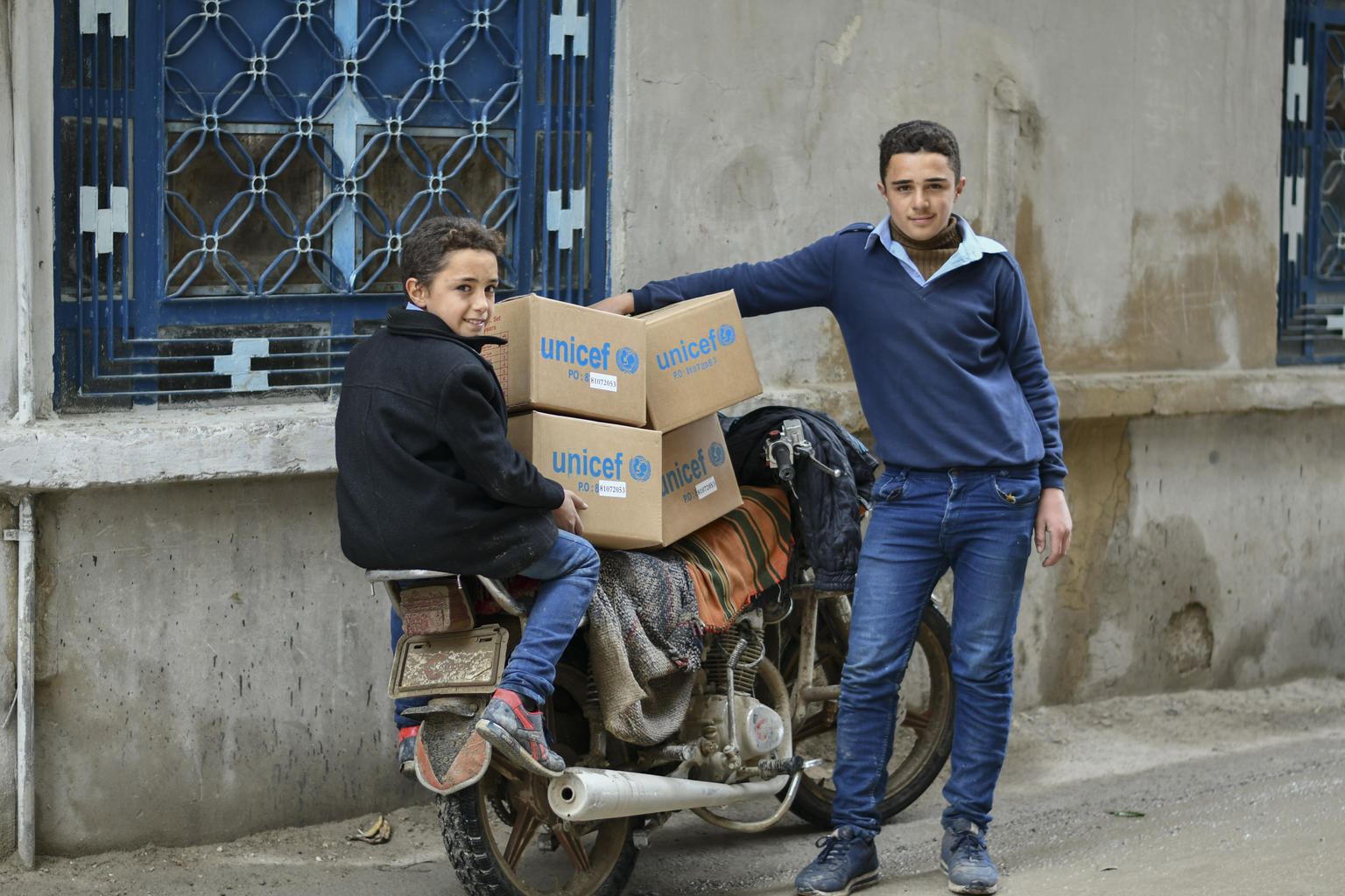 Akram y Mohamed, dos niños hermanos de Siria con el kit de invierno de UNICEF