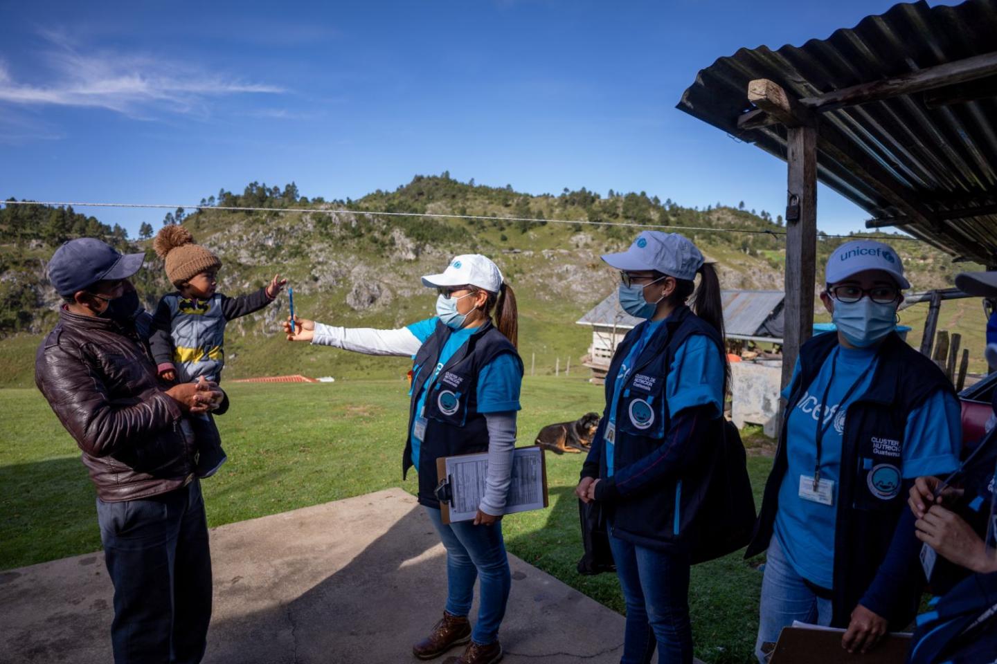 Brigadas nutricionales de Guatemala ayudando a un niño de una zona montañosa aislada