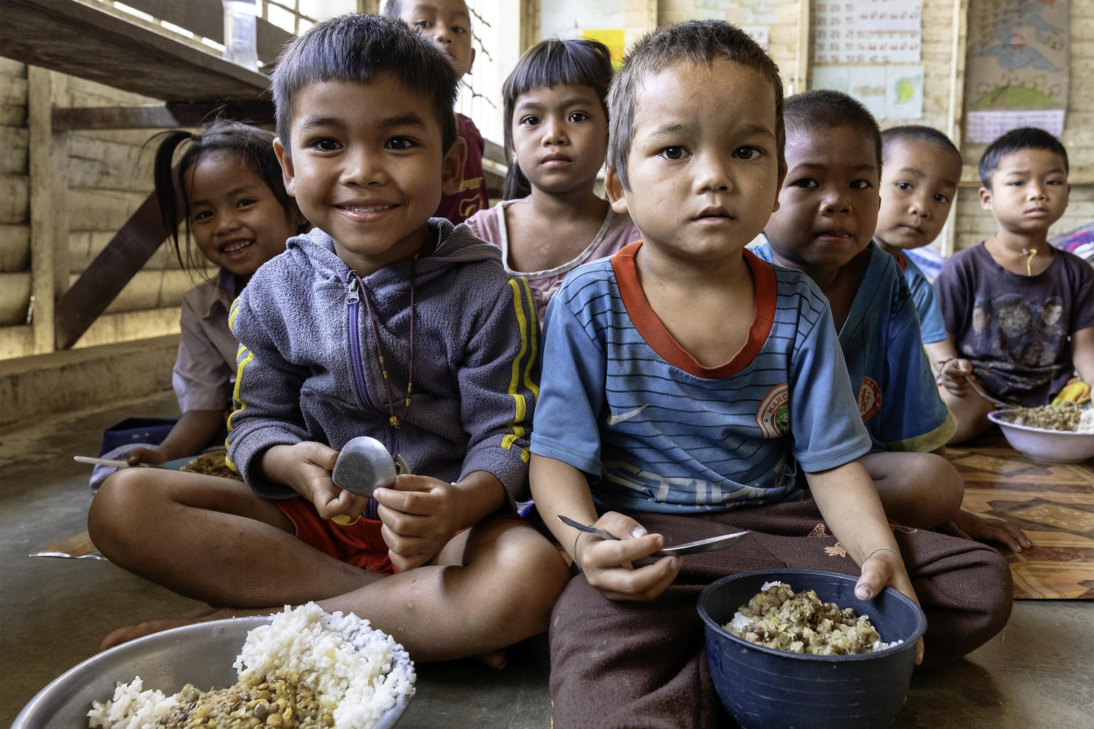 Niños comiendo su menú escolar en un colegio temporal
