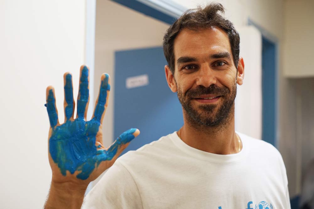 Calderón con la mano azul colaborando con Unicef