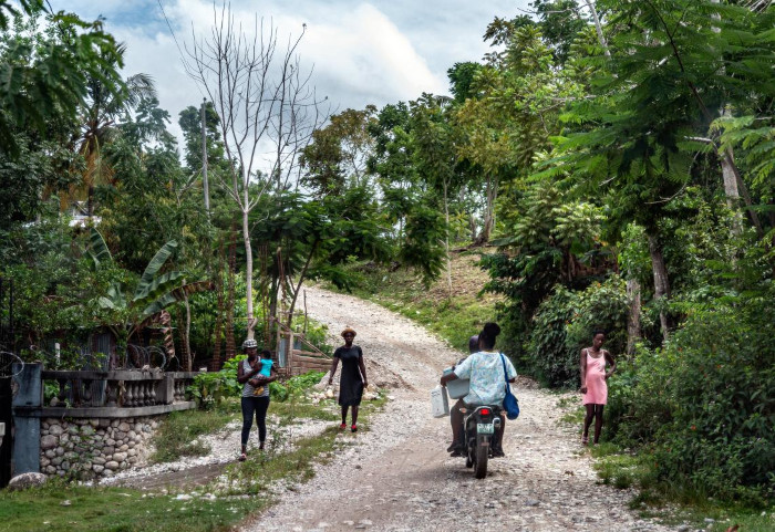 Viaje en motocicleta a un sitio remoto de Haití para distribuir las vacunas de los niños. 