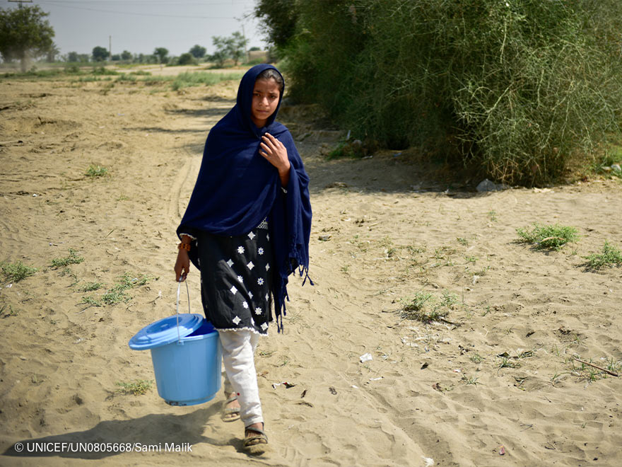 Imagen de una niña recogiendo agua