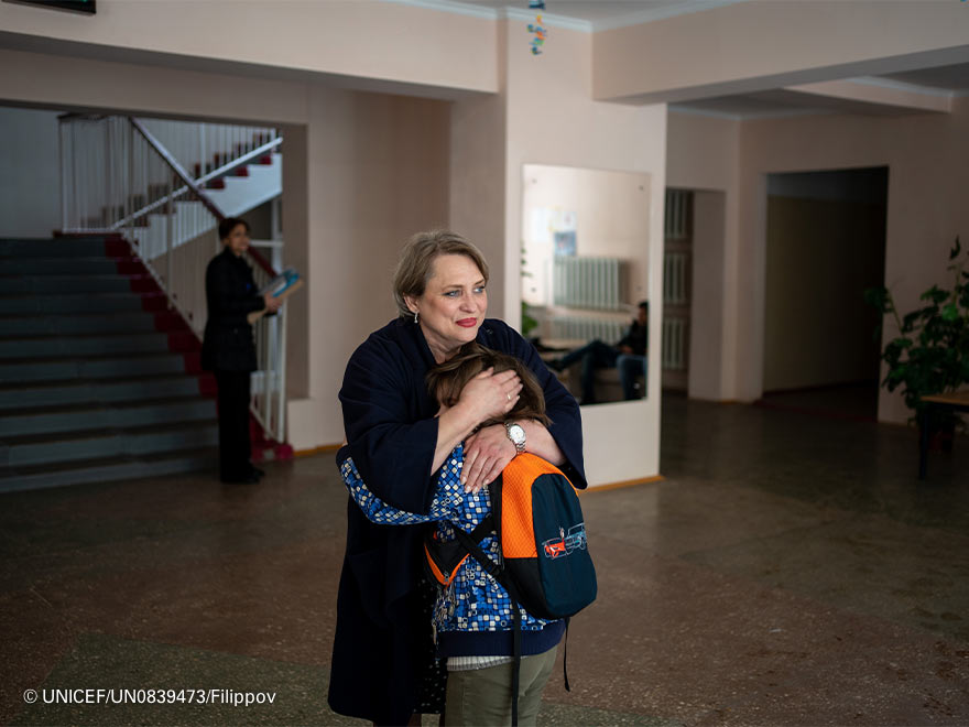 Imagen de una mujer abrazando a un alumno