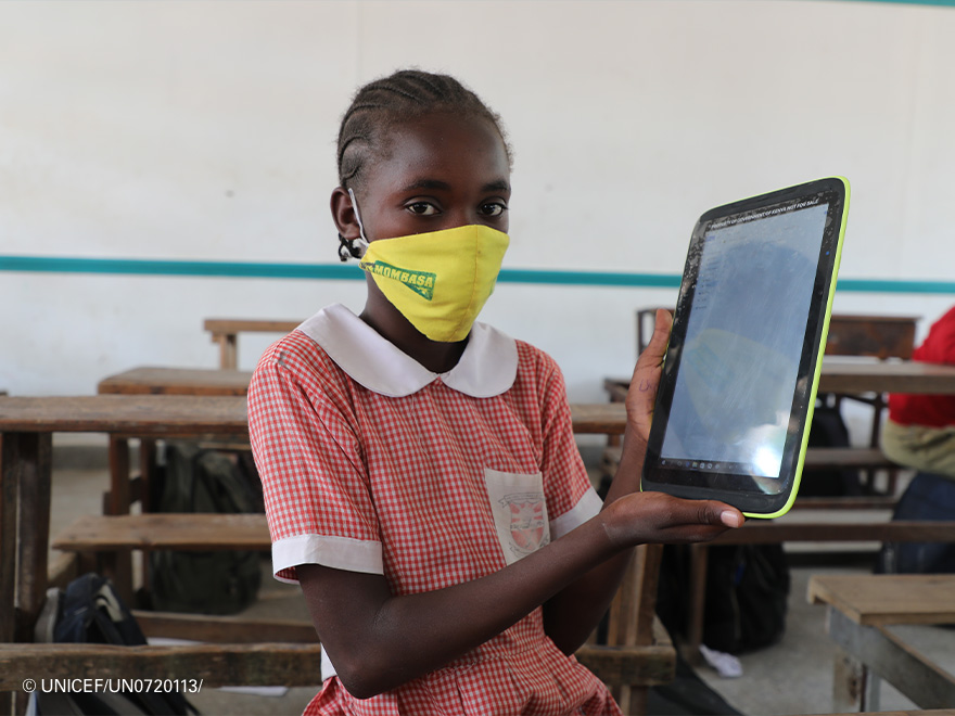 Una de las niñas del colegio nos enseña su tablet para aprendizaje digital.