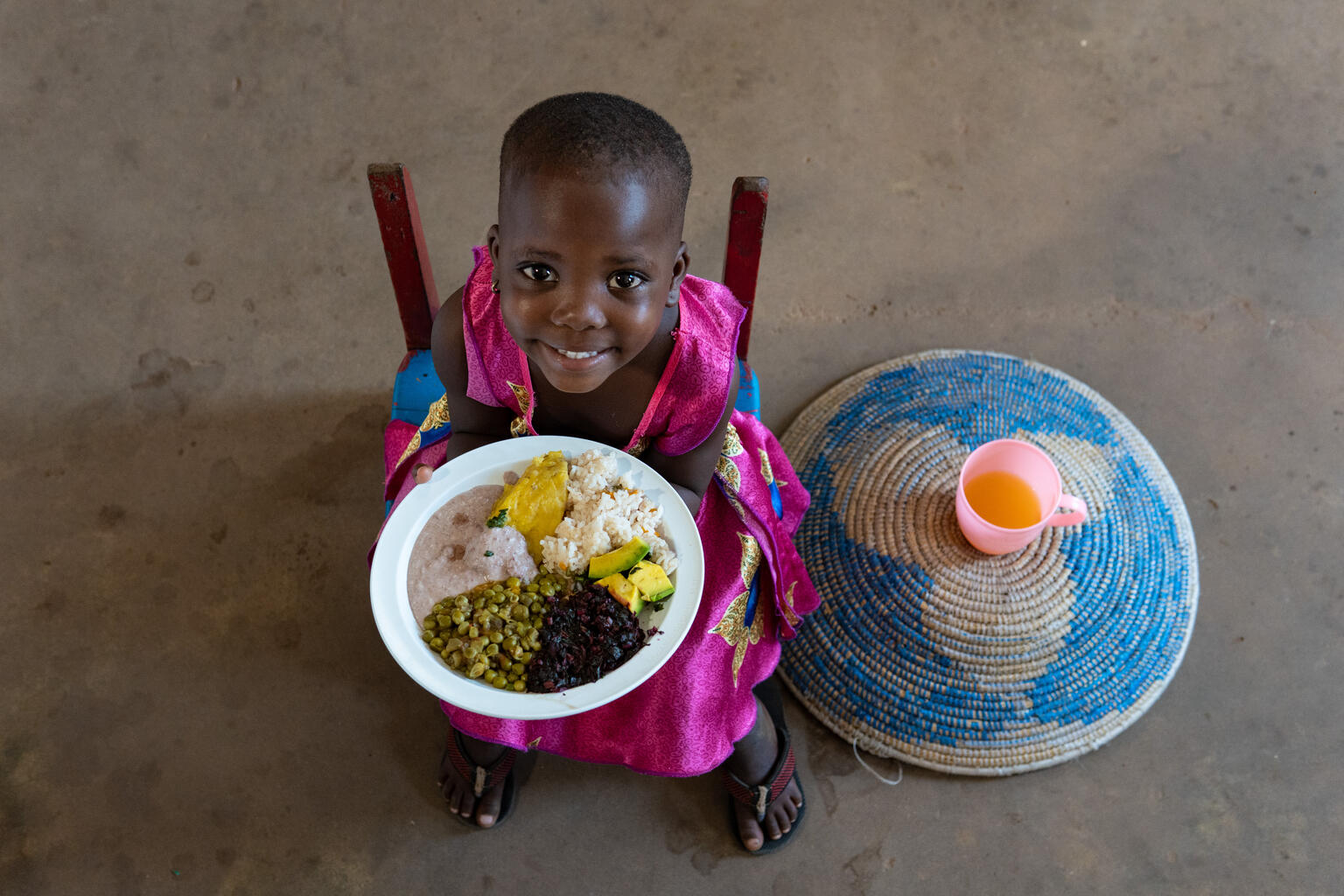 Una niña come su ración de comida en Uganda