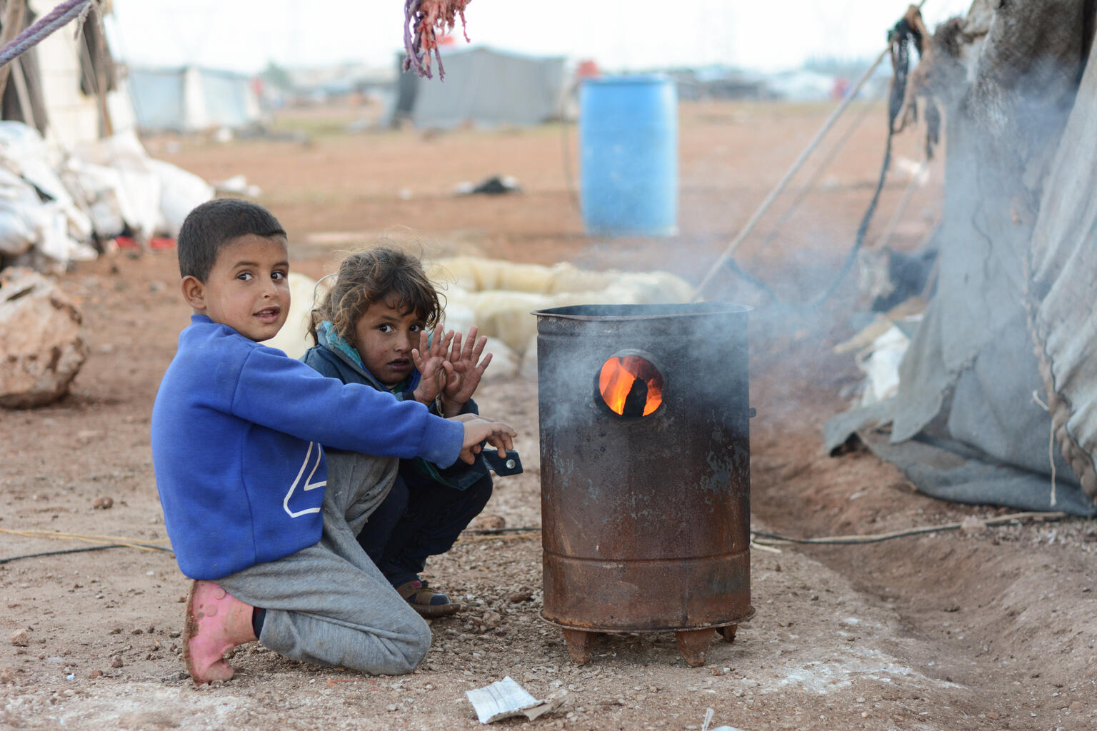 Niños refugiados de Siria al calor de una hoguera en el frío invierno