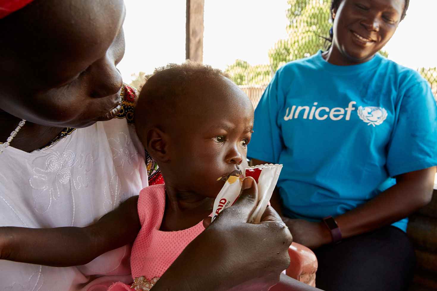 Trabajadores de UNICEF alimentan a la pequeña Adut