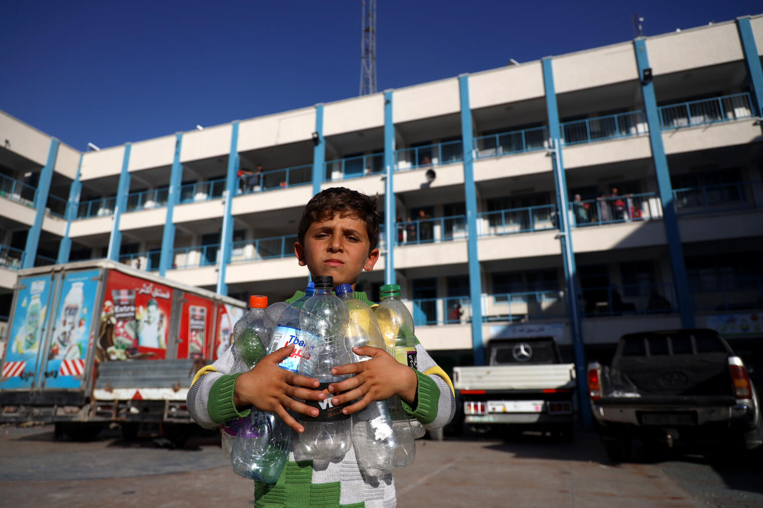 Niño palestino con botellas vacias para rellenarlas de agua