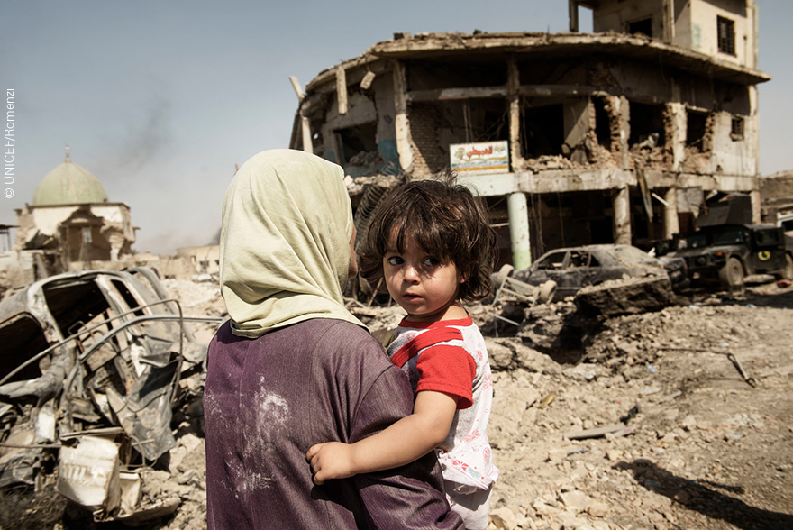 Mujer y niño salen del casco viejo de Mosul
