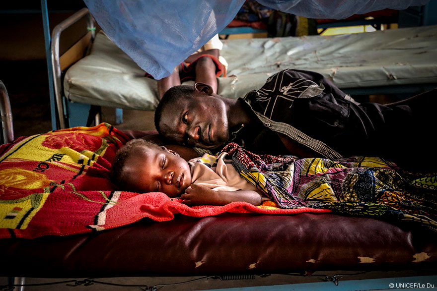 Prosper observa a Pierre mientras descansa en una cama del Hospital Infantil de Bangui