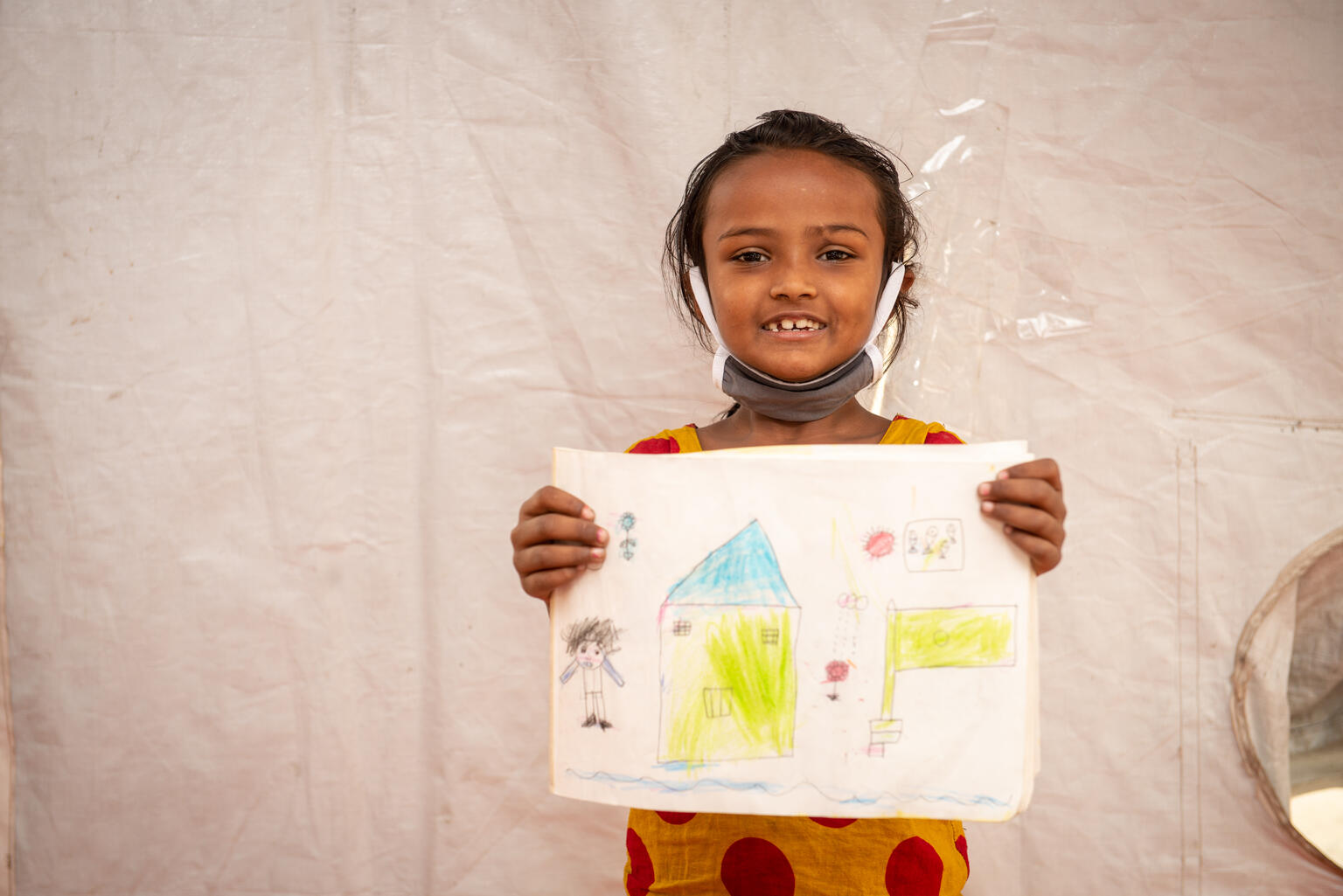Una niña rohingya enseña un dibujo en Bangladesh