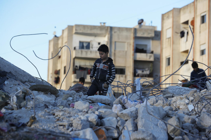 Un niño camina entre los escombros que dejó el terremoto en Siria.