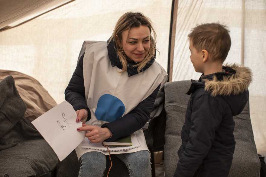 En un punto azul de UNICEF, una psicóloga ayuda a un niño de Ucrania.