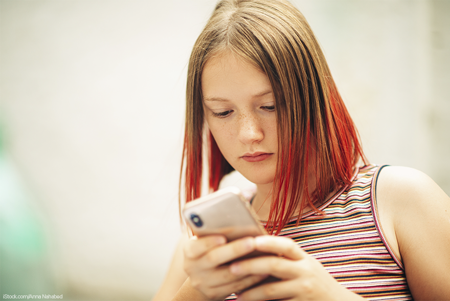 Una adolescente mira la pantalla de un movil