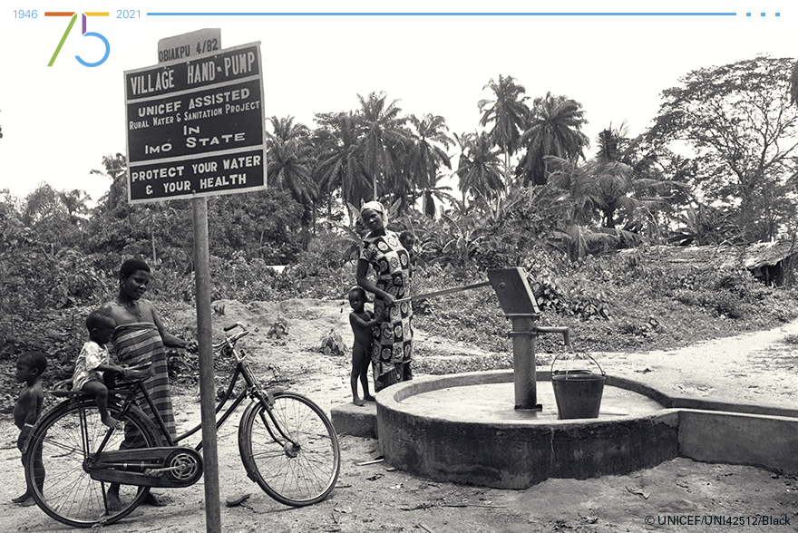 Dos mujeres y sus hijos junto a un pozo perforado instalado por UNICEF en 1982 en su aldea, en Nigeria.