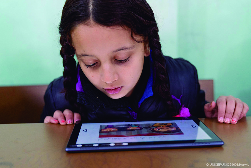 Una niña mira la pantalla de una tablet durante una actividad educativa