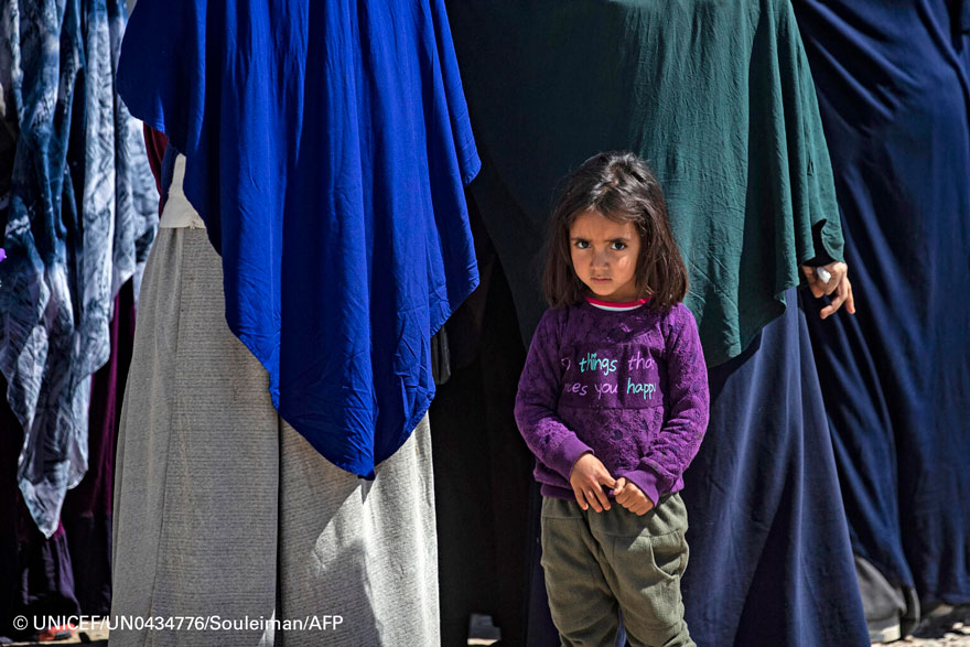 Una niña junto a un grupo de mujeres en un campamento para desplazados de Siria