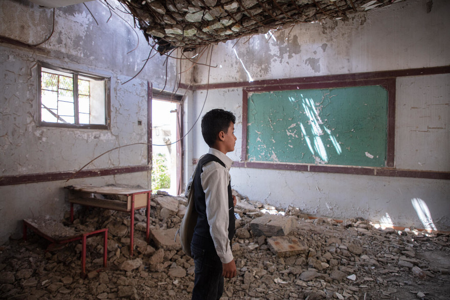 Un niño en Yemen asiste a una escuela destruida por el conflicto.