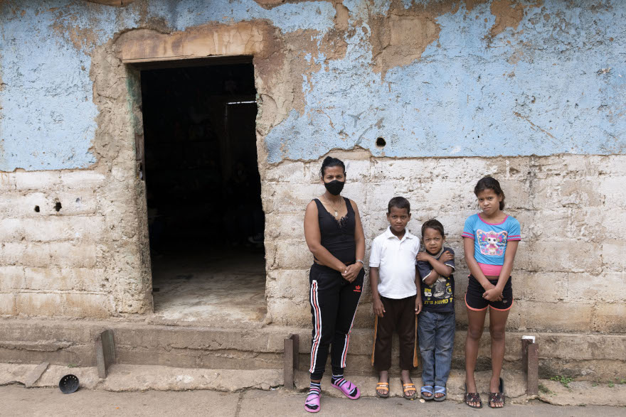 Yoli y sus tres hijos en una improvisada vivienda en Venezuela.