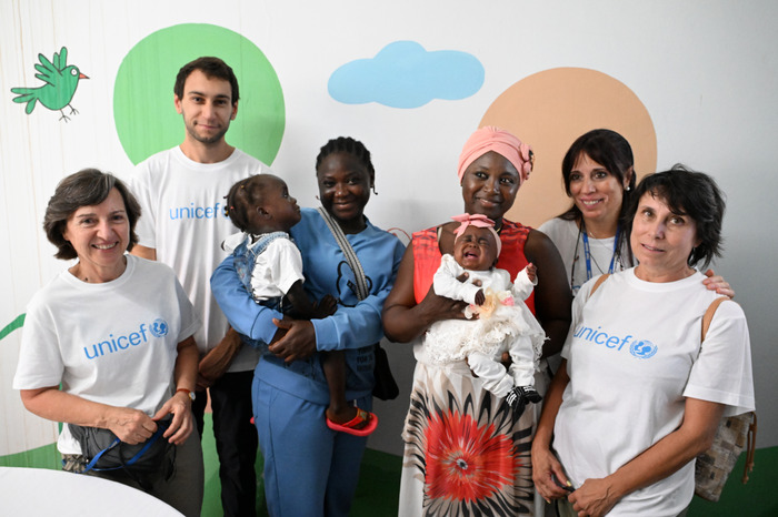 Inma, Maca, Carles y Casti, los cuatro socios de UNICEF España que viajaron a Costa de Marfil en 2024, junto a varias beneficiarias durante la misión.