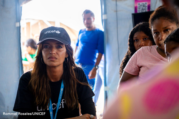 Sara Carbonero escucha atentamente las historias de los migrantes, en un espacio seguro de UNICEF