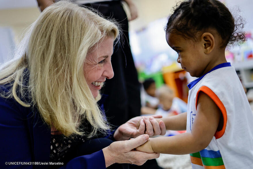 La directora ejecutiva de UNICEF saluda a una niña pequeña durante su visita a Brasil
