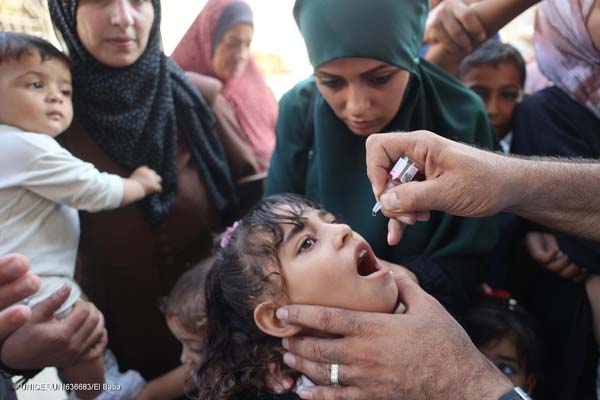 Un equipo de UNICEF suministra la vacuna oral contra la poliomelitis a una niña en la Franja de Gaza