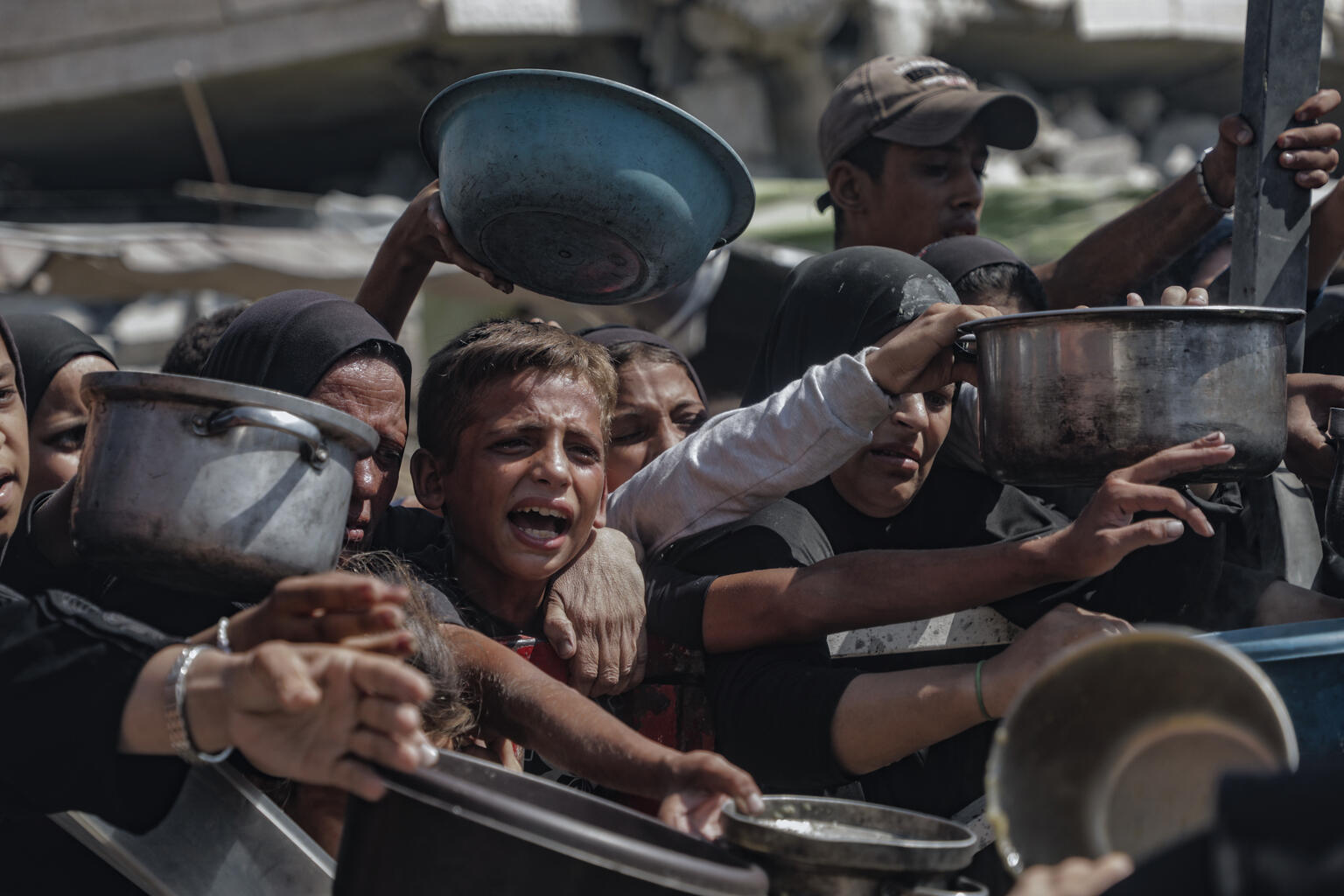 niño intentando conseguir algo de comida en Gaza