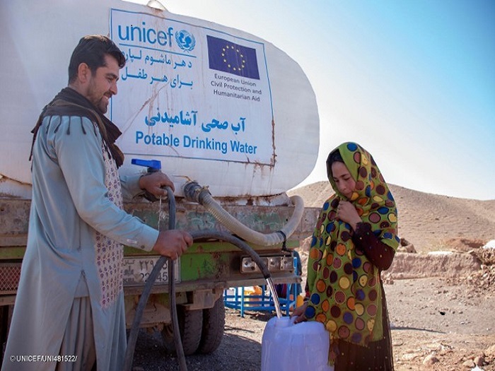 Niña recoge agua suministrado por un camión cisterna de UNICEF