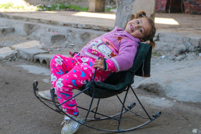 Amneh sentada en una hamaca en el patio de su casa en Siria.