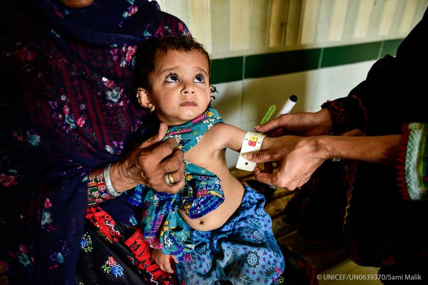 Una especialista mide la circunferencia del brazo de un niño pequeño en Pakistán