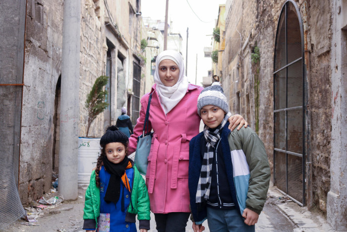 Una madre con sus niños a la salida de un centro de protección infantil de UNICEF en Siria.