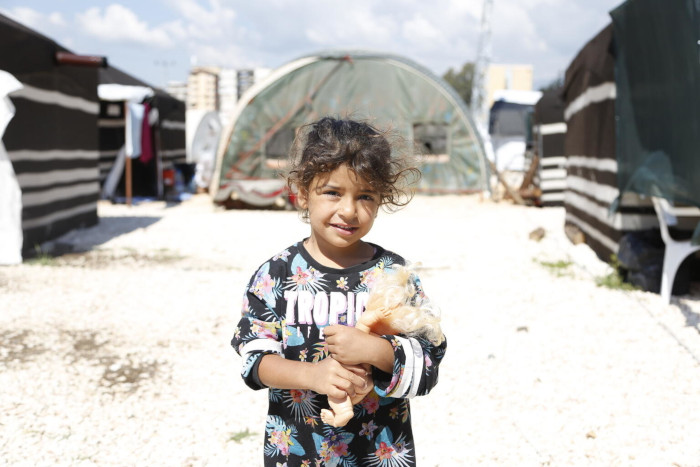 Una niña con su muñeco en uno de los refugios temporales en Turquía después de los terremotos.