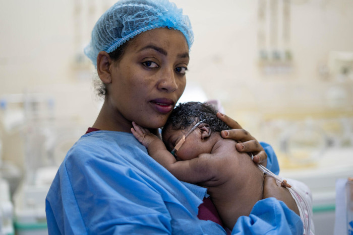 Omnia junto a su madre, en una Unidad de Cuidados Intensivos, en Sudán.