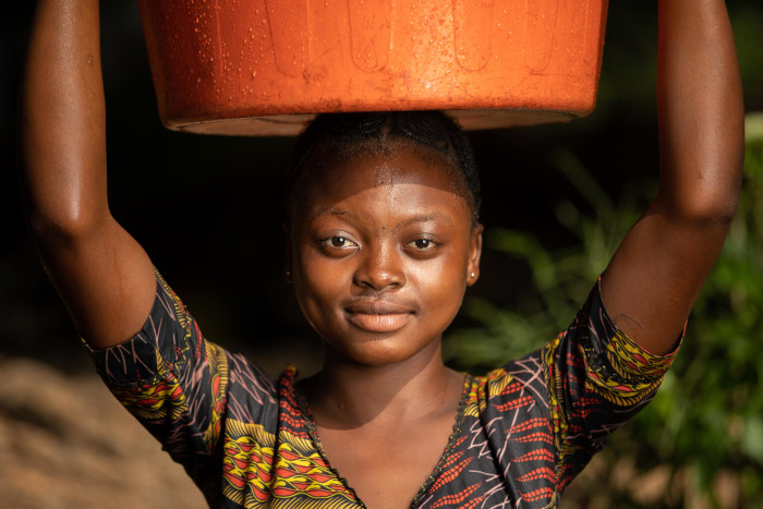 Una niña recoge agua en una fuente establecida por UNICEF.