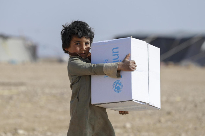 Un niño recoge suministros de invierno distribuidos por UNICEF en Siria.