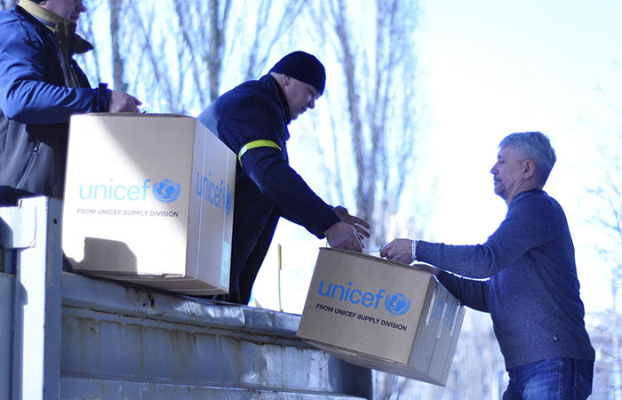 Imagen de dos trabajadores de UNICEF descargando cajas con suministros