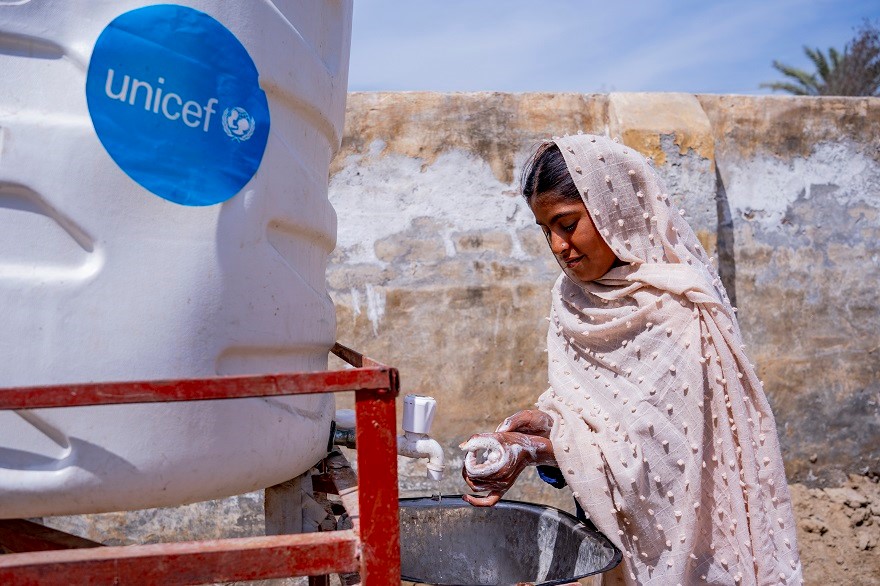 Una niña se lava las manos en una estación de lavado de manos instalada por UNICEF Pakistán