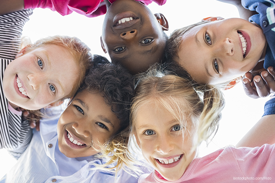 Un grupo de niños y niñas posan sonrientes para una foto