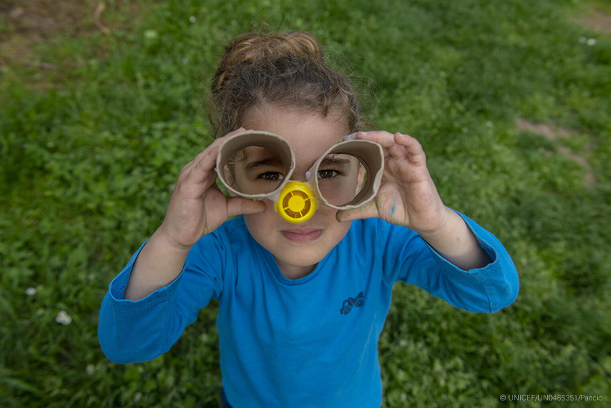 Una niña mira a través de unos anteojos de cartón