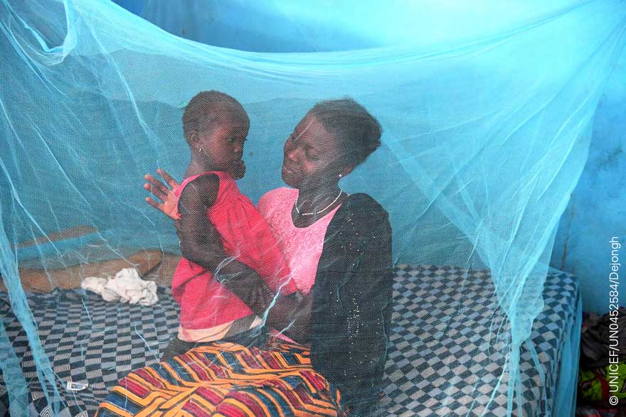 Una madre y su hija se protegen de los mosquitos bajo una red en Costa de Marfil