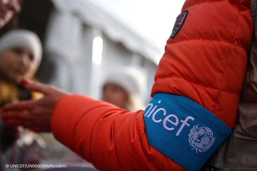 Un miembro del personal de UNICEF proporciona información a un grupo de personas refugiadas recién llegadas a Rumanía