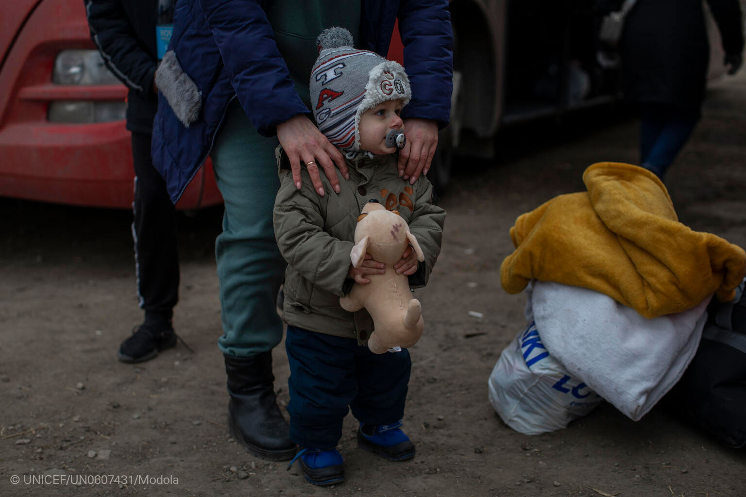 Un niño espera junto a su familia en un centro de recepción de personas refugiadas en la frontera entre Ucrania y Moldavia