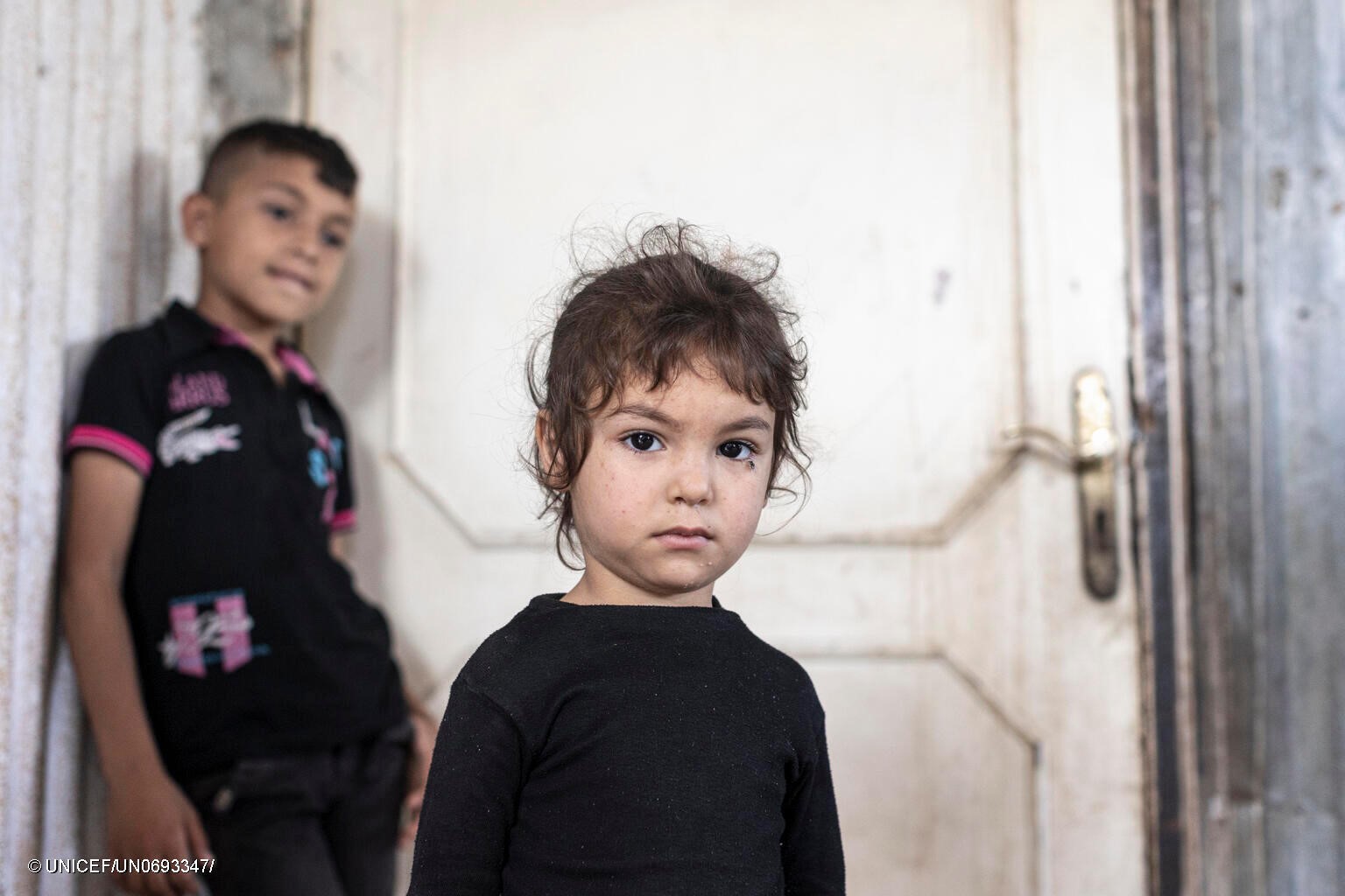 Hind, de 4 años, refugiada de Siria, junto a su familia en el exterior de la casa precaria en la que viven en Saida (Líbano).